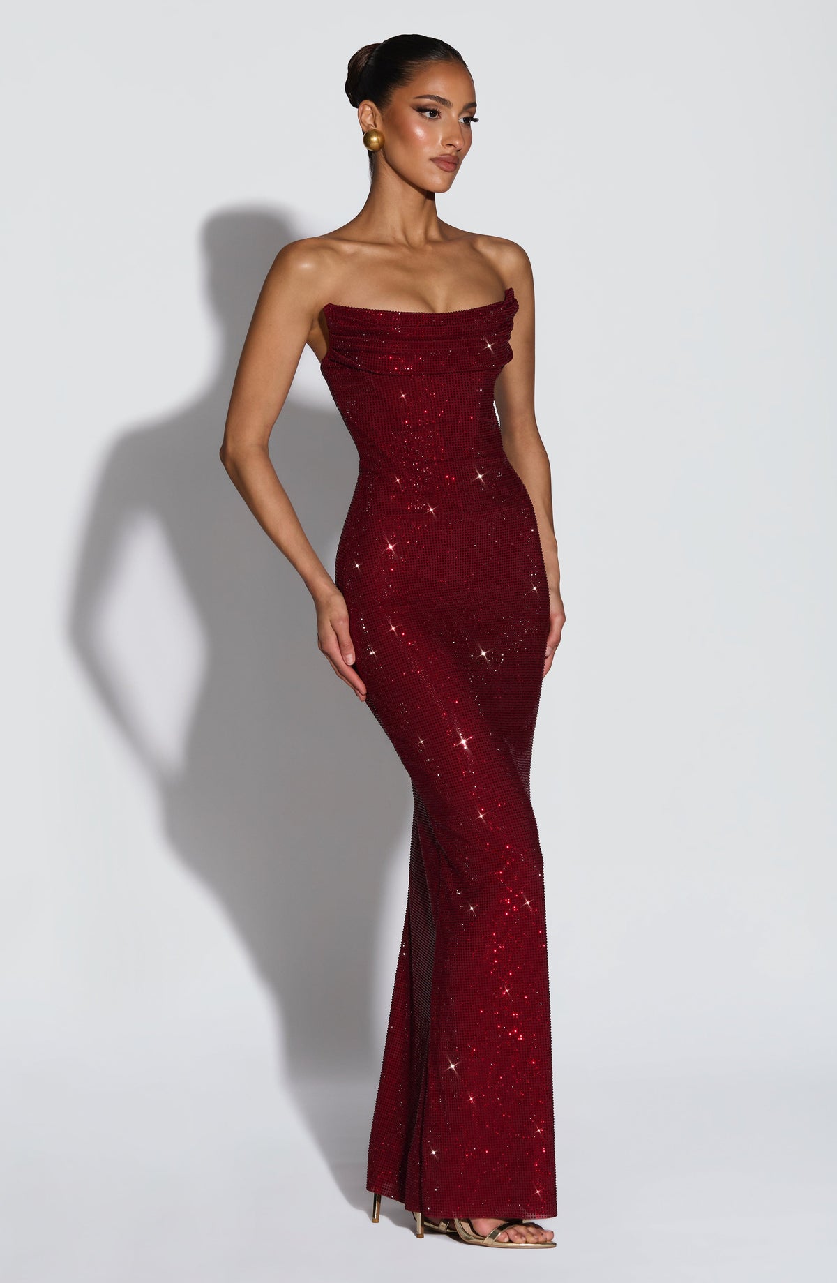 Three-quarter view of the burgundy dress, showing the fitted silhouette and floor-length hem 4