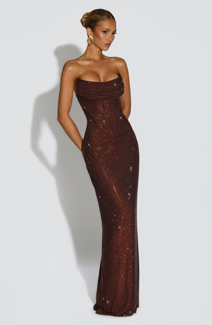 Angled view of the brown dress, model with a hand behind her back and gold sculptural earring 12