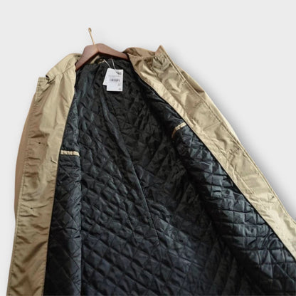Beige coat on a wooden hanger, opened wide to show the black diamond-quilted lining 6