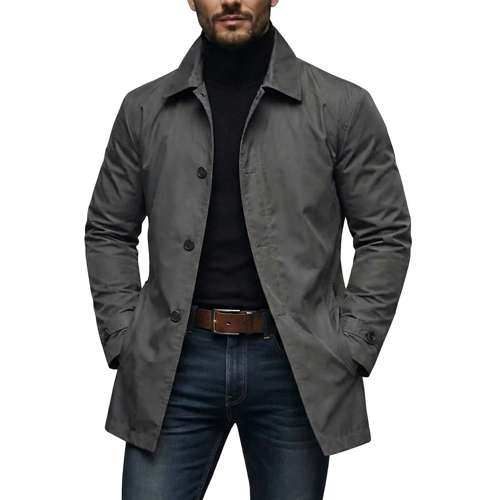 Model wearing the grey coat open over a black roll-neck, jeans and brown leather belt, hands in pockets 1