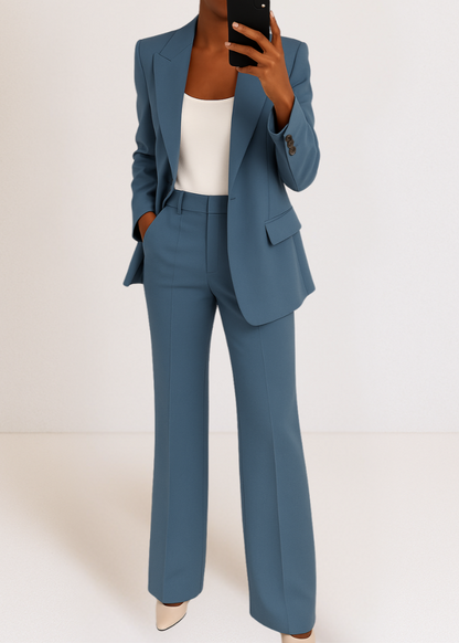 Model taking a mirror selfie in the steel blue blazer and wide-leg trousers, worn over a white top with cream heels. 1