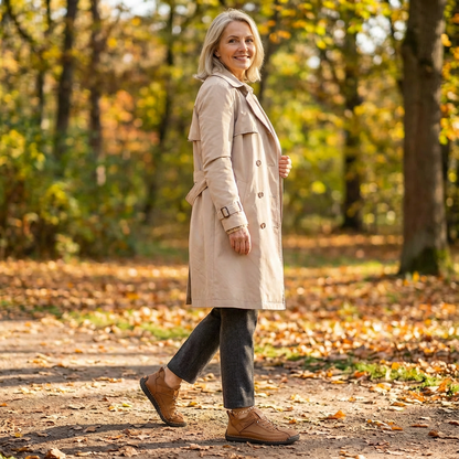 Woman in trench coat walks along an autumn woodland path in tan brown trainers 18
