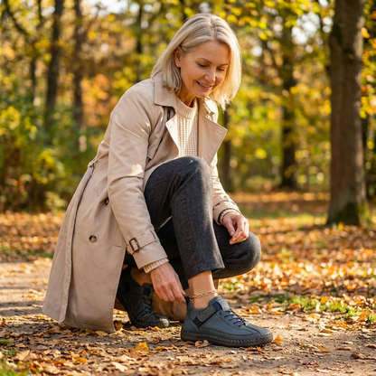 Woman crouches on an autumn path, adjusting her blue trainers, with a black pair beside her 20