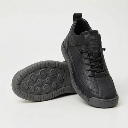 Black textured trainers with elastic laces, one resting on its side to show the grey patterned sole 3
