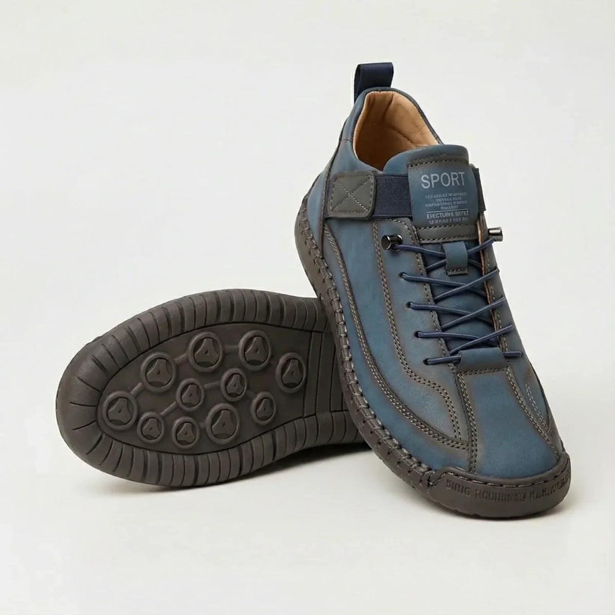 Blue trainers with navy elastic laces and strap, one tilted to display the grey-brown tread 6