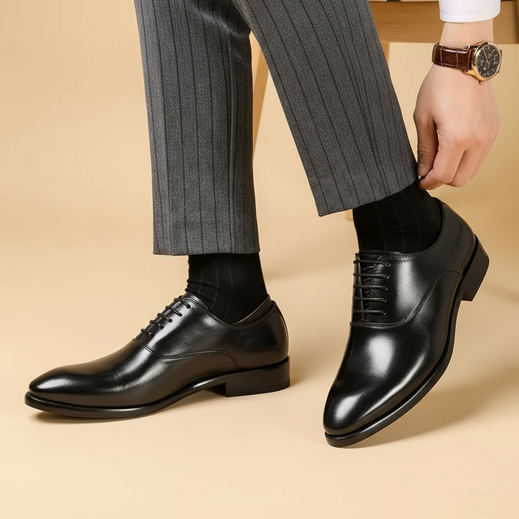 Black polished leather Oxfords worn by a model in pinstripe trousers, shown from a three-quarter angle 3