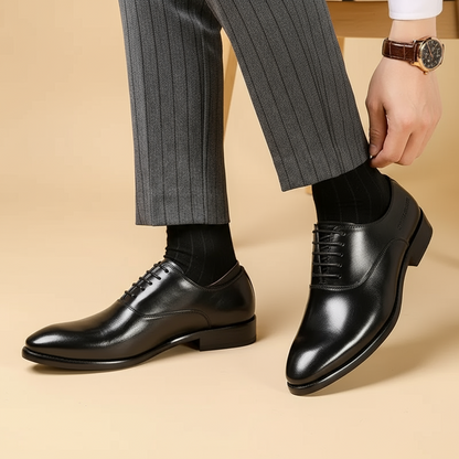 Black polished leather Oxfords worn by a model in pinstripe trousers, shown from a three-quarter angle 3