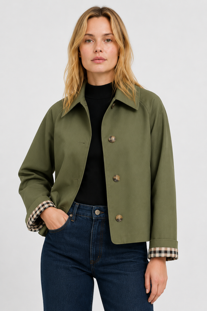 Model wears the olive green jacket over a black top and jeans, hand in pocket, gingham cuff lining showing. 7