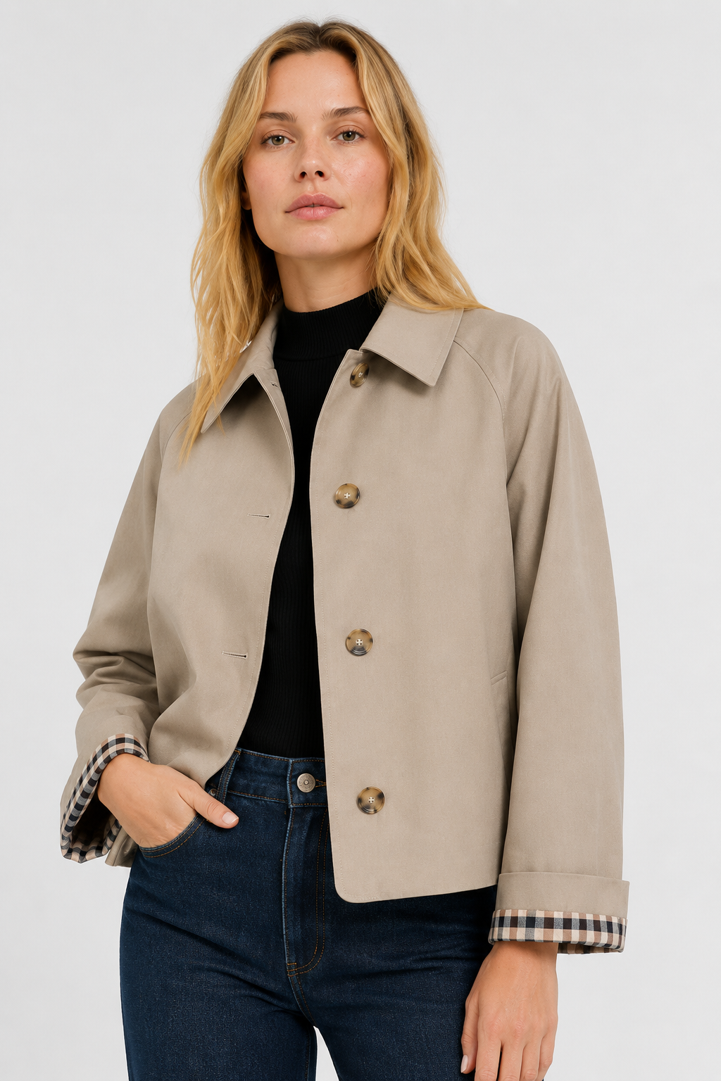 Model wears the beige button-up jacket open over a black top and jeans, one hand in pocket, gingham cuff lining visible. 1
