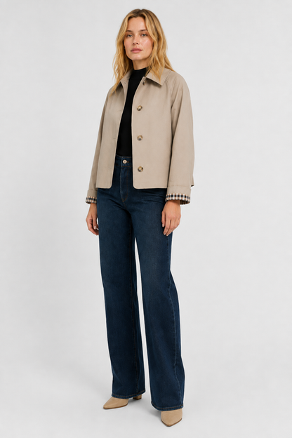 Full-length view of a model in the beige jacket with a black top, wide-leg dark jeans and beige boots. 4