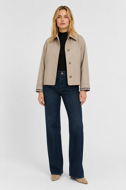 Full-length front view of the beige jacket worn with a black top, dark wide-leg jeans and pointed beige boots. 5