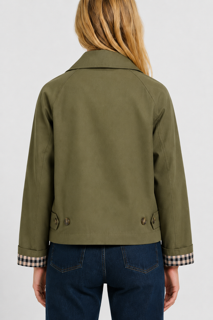 Back view of the olive green jacket with raglan sleeves, two buttoned hem tabs and gingham cuff lining. 9