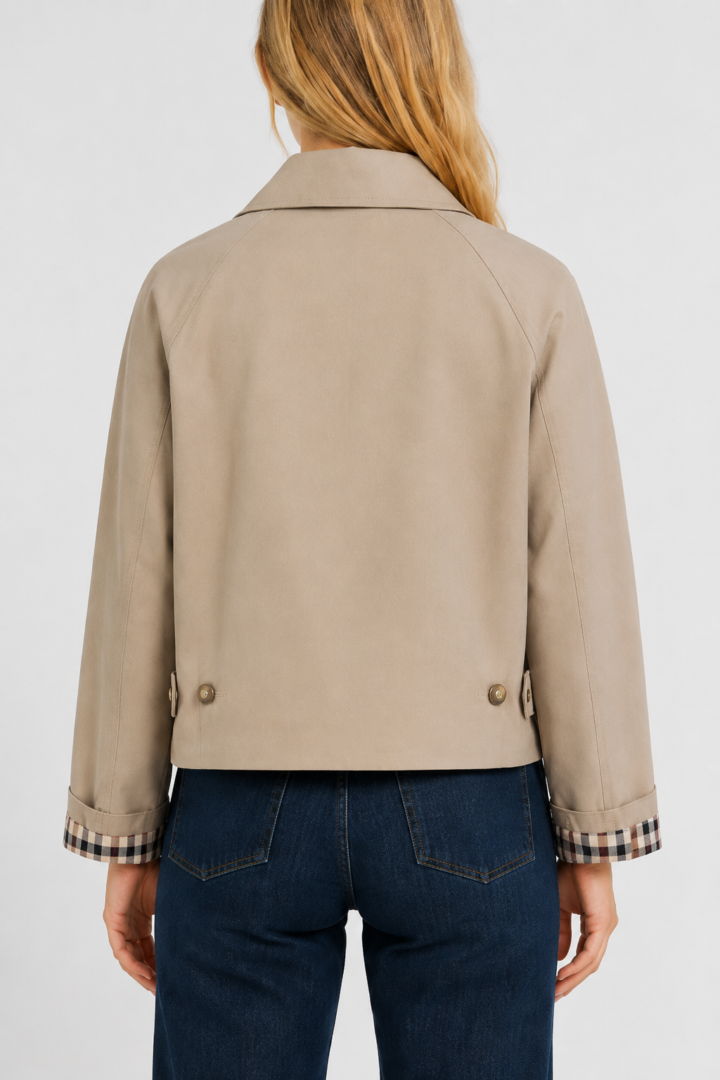 Back view of the beige jacket with raglan sleeves, two buttoned tabs at the hem and gingham cuff lining. 3