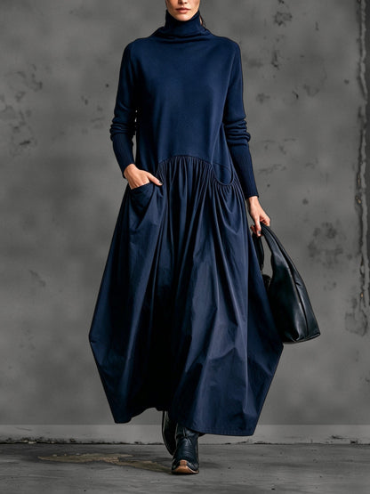 Front view of the dress in deep navy blue, with a hand in the pocket and black boots 6