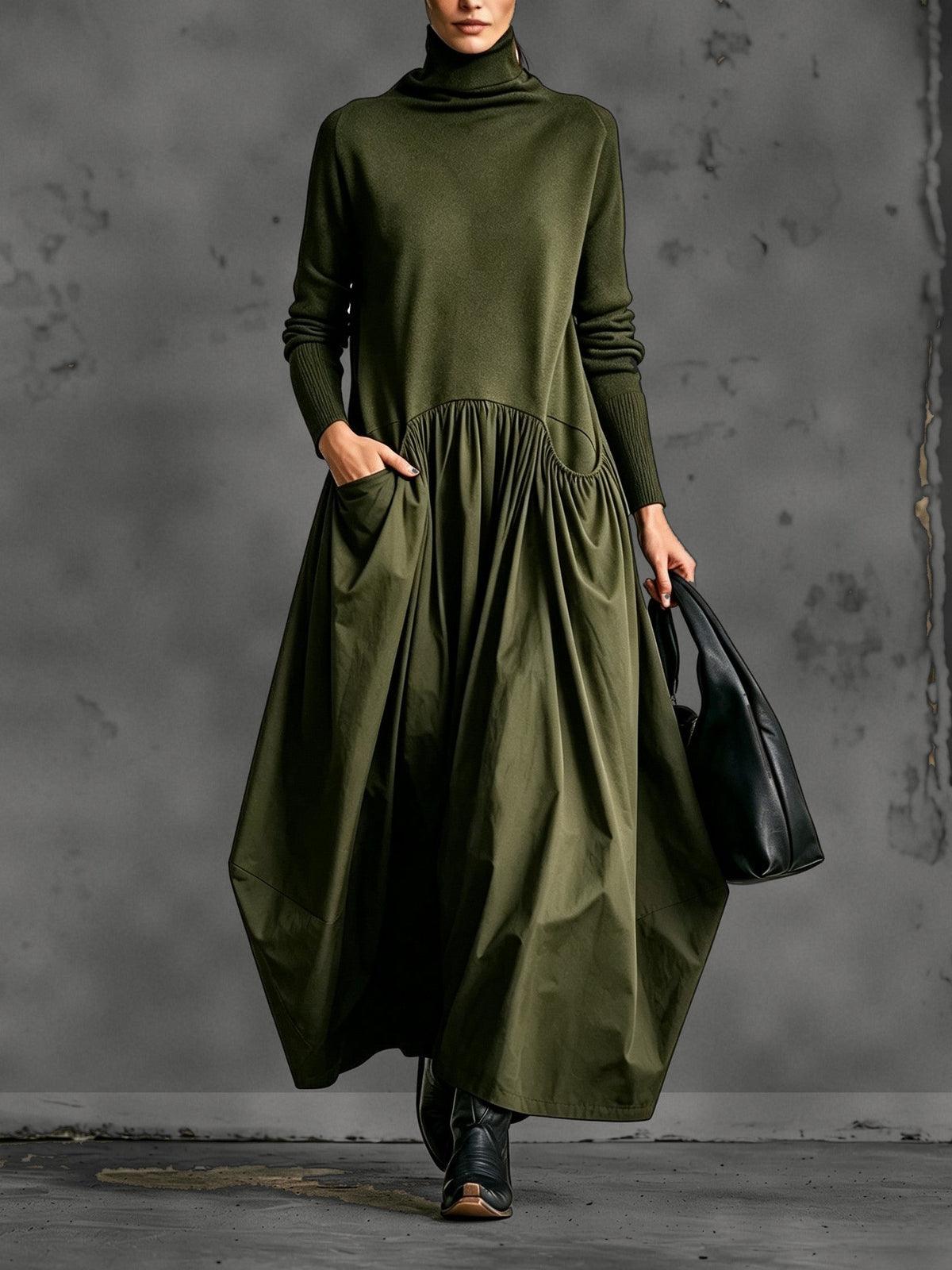 Front view of the dress in olive green, worn with black boots and a hand in the pocket 4