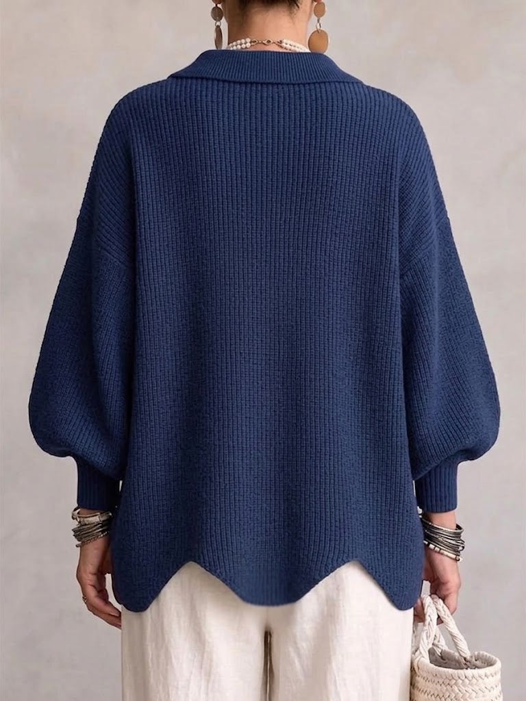 Back view of the navy version on a model, showing plain ribbed knit, folded collar, balloon sleeves and scalloped hem. 7