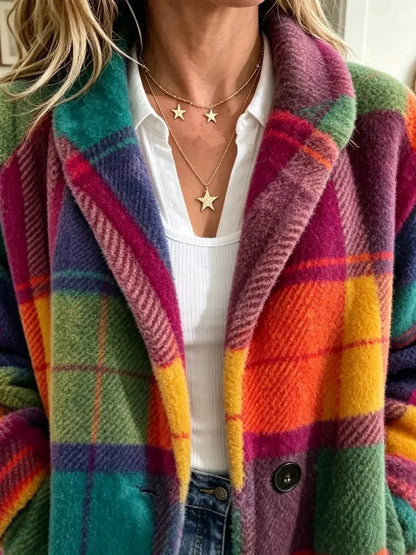 Close-up of the notched lapel and single button of the soft checked coat, worn over a white top with star necklaces. 3
