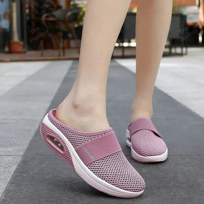 Dusky pink mesh slip-on mules with white sole, worn by a model standing on a paved path 4