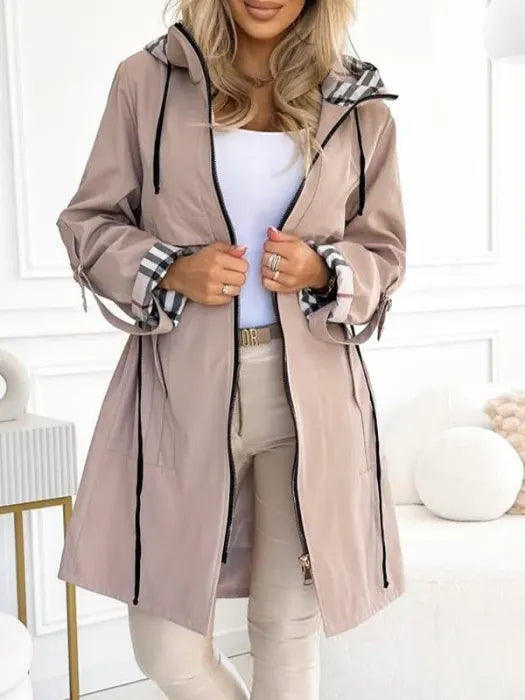 Model in the beige hooded jacket worn open with a white top and beige trousers, showing zip, drawcords and checked cuff lining. 2