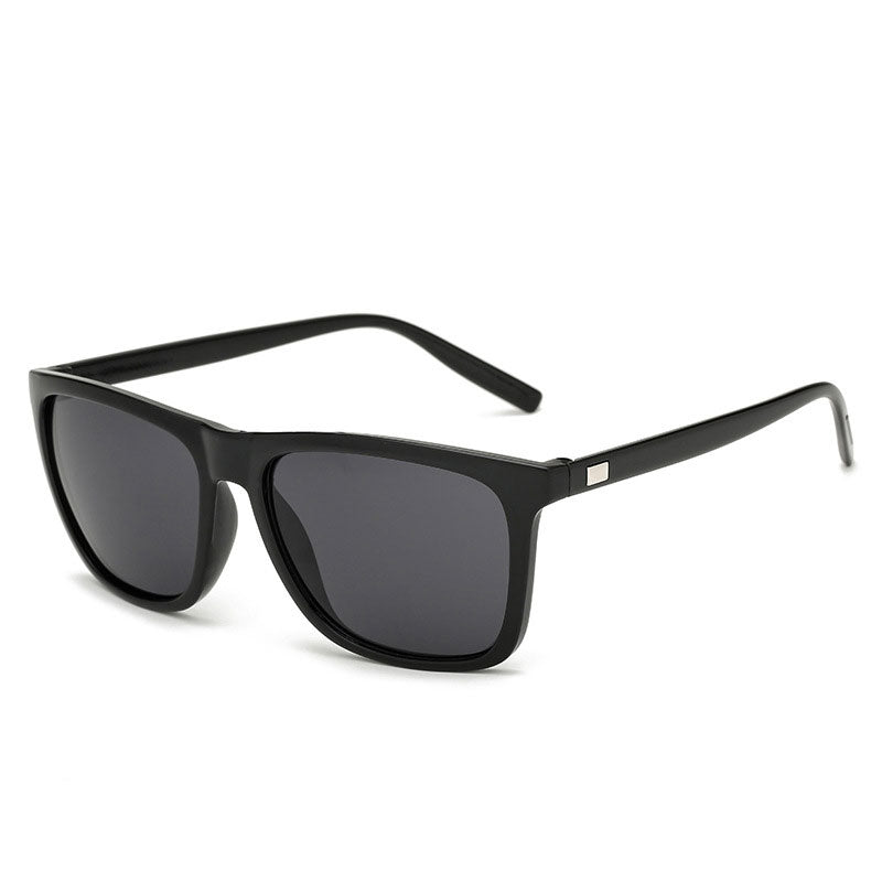 Angled view of glossy black-framed sunglasses with dark grey lenses and metal plate on the arm 13