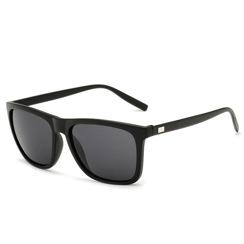 Angled view of matte black sunglasses with dark grey lenses and a small metal plate on each arm 7