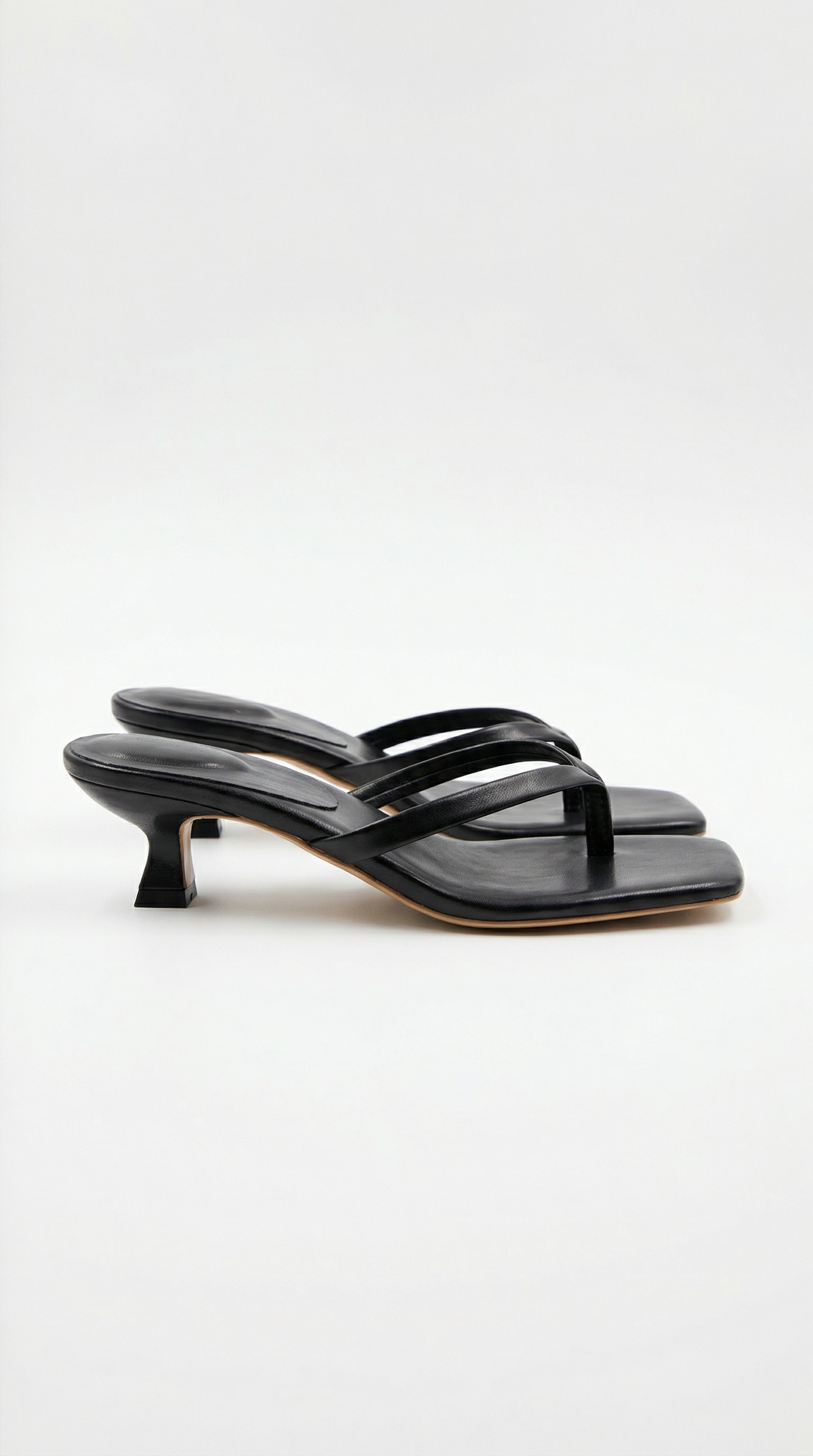 Pair of black kitten-heel thong sandals with a square toe, shown from the side on a plain light background. 1