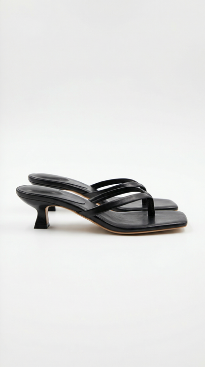 Pair of black kitten-heel thong sandals with a square toe, shown from the side on a plain light background. 1