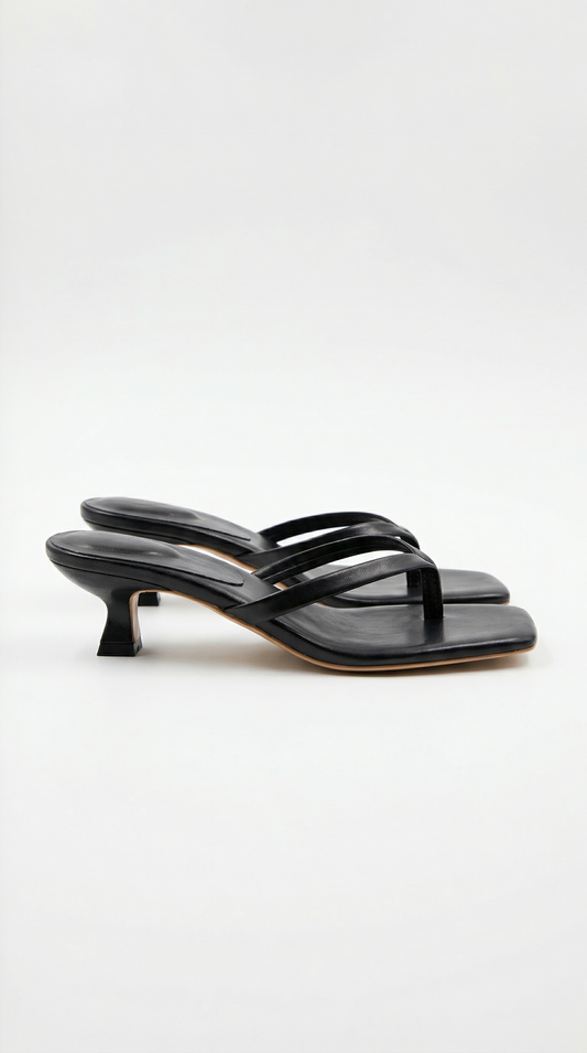 Pair of black kitten-heel thong sandals with a square toe, shown from the side on a plain light background. 1