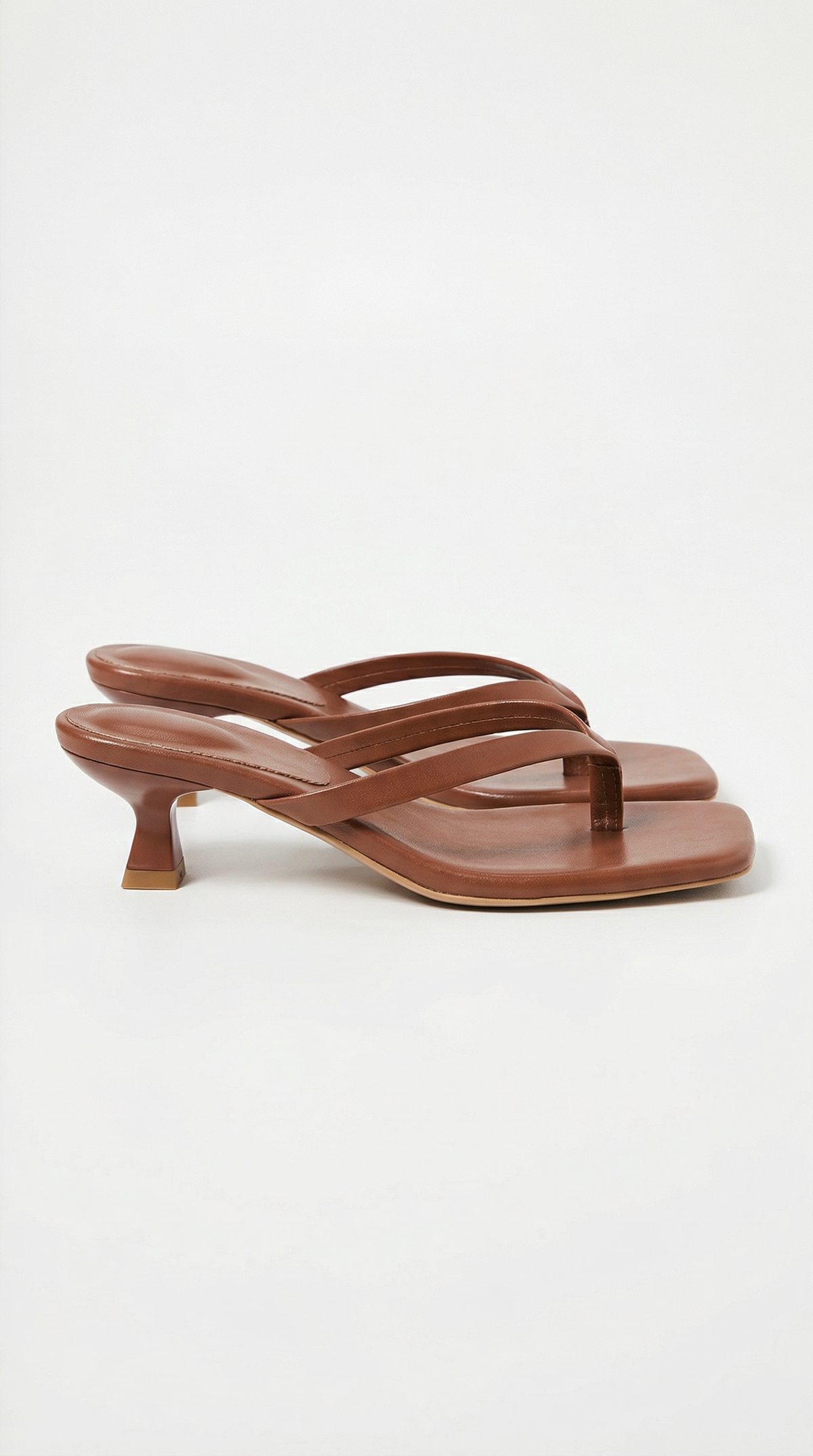 Pair of chestnut brown kitten-heel thong sandals with padded straps and square toes, shown from the side. 16
