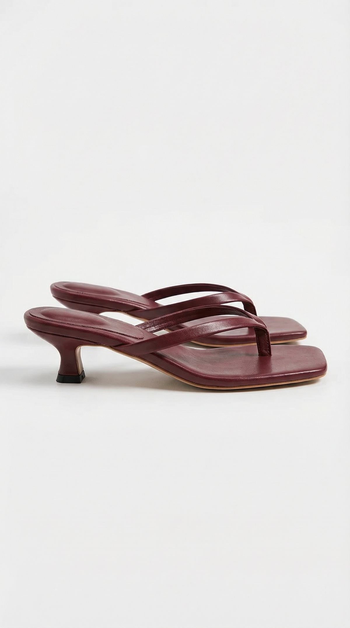 Pair of deep burgundy kitten-heel thong sandals with square toes and a flared heel, shown from the side. 13