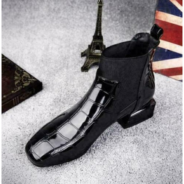 Glossy black embossed ankle boot photographed from above on grey carpet, toe and elastic side visible 7
