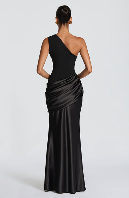 Front view of the black one-shoulder maxi dress, crepe bodice with draped satin hip panel and floor-length skirt. 40