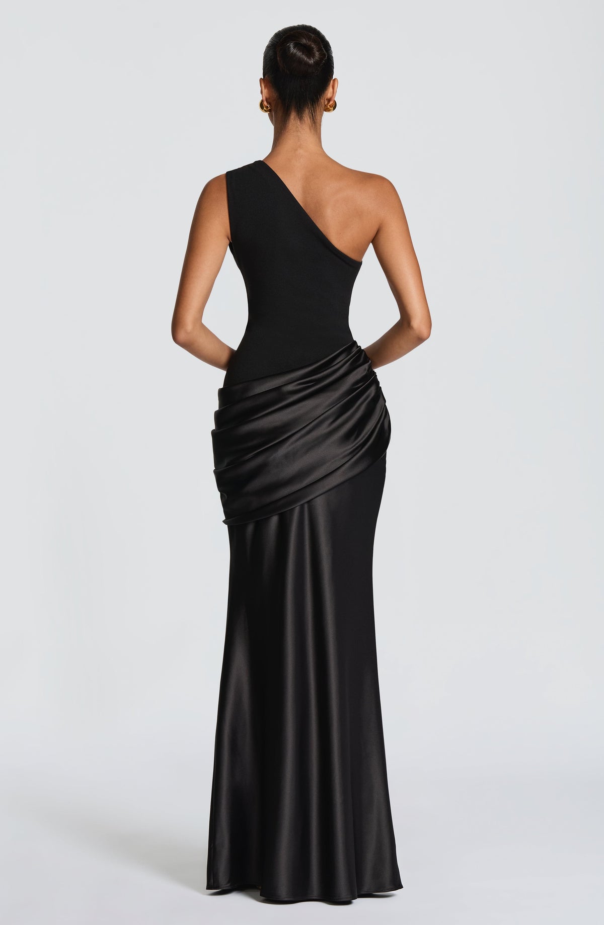 Back view of the black one-shoulder dress on a model, showing the draped satin hip panel 21