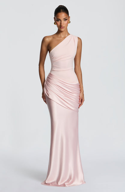Three-quarter view of the blush pink maxi dress, hand on hip, showing the ruching and glossy satin skirt. 30