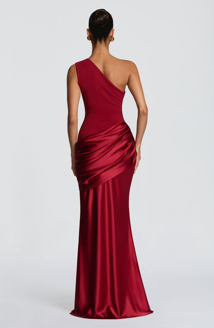 Back view of the red one-shoulder maxi dress, with the diagonal strap and gathered satin hip drape. 16