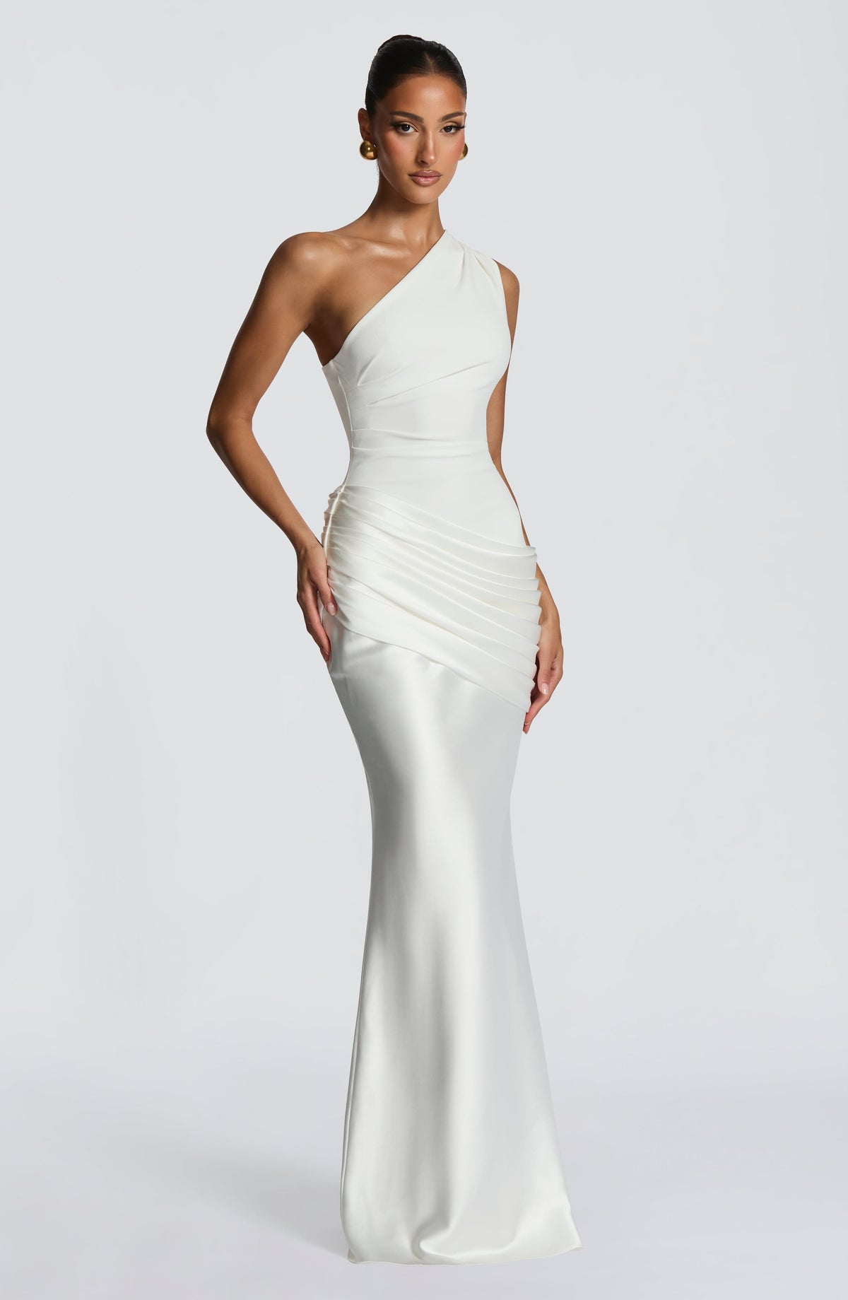 Three-quarter front view of the white dress, hand on hip, showing the pleating at the waist and flared satin skirt. 24