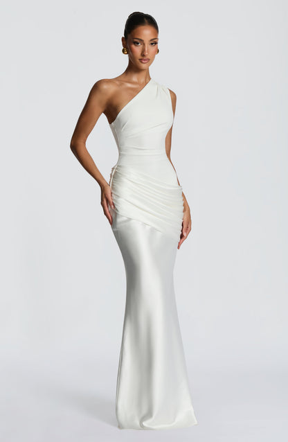 Three-quarter front view of the white dress, hand on hip, showing the pleating at the waist and flared satin skirt. 24