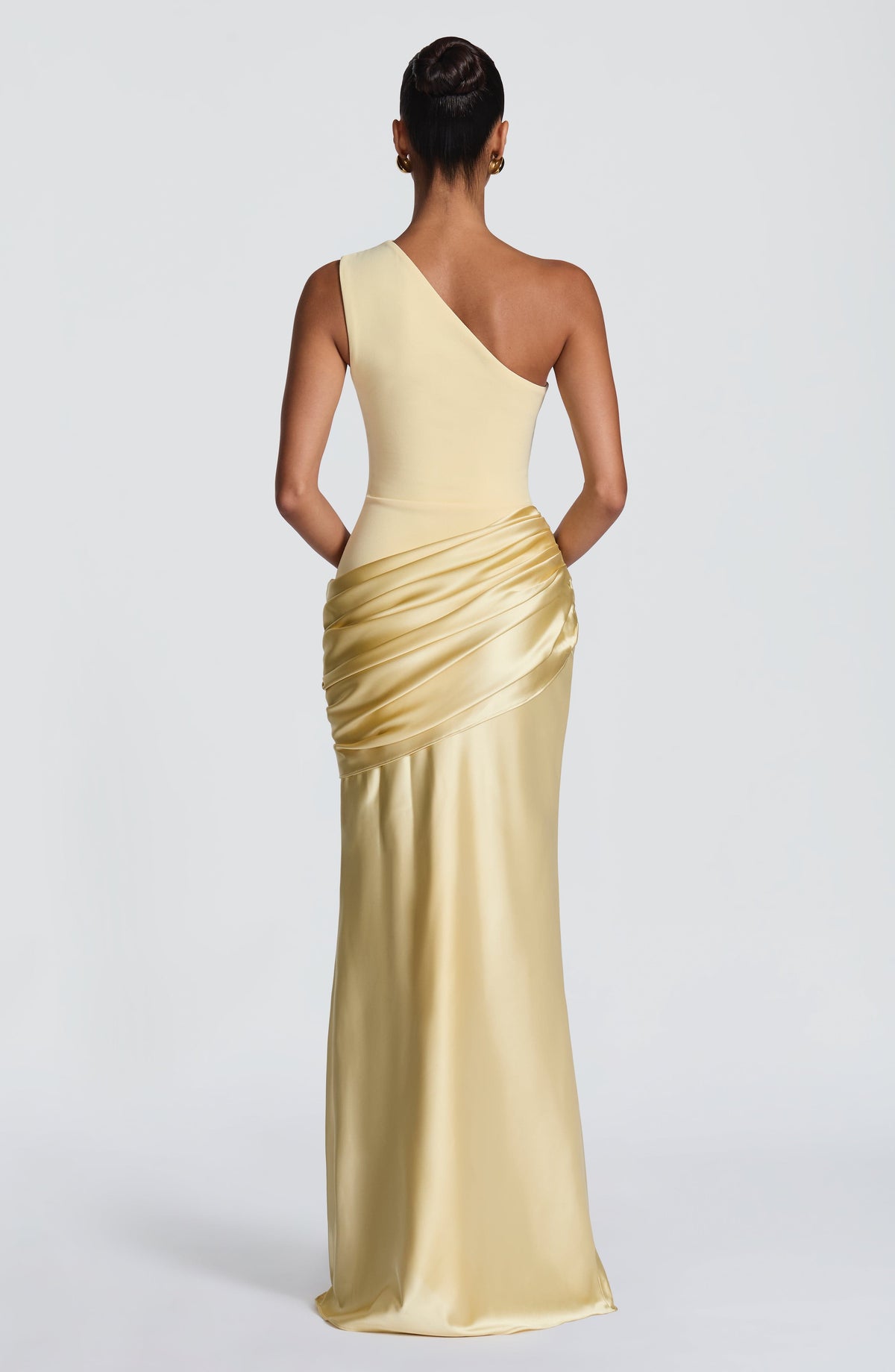 Back view of the pale yellow dress, showing the asymmetric one-shoulder cut and gathered satin drape across the hips. 46