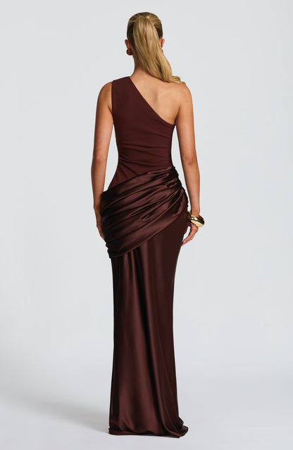 Back view of the brown one-shoulder maxi dress showing the diagonal strap and gathered satin drape at the hip. 11