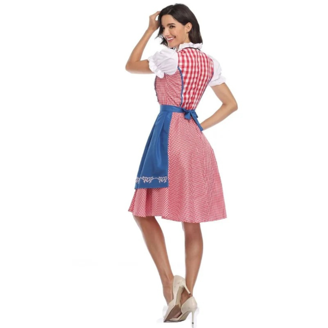 Back view of the red check dirndl with blue apron tied in a bow, the model glancing over her shoulder. 9