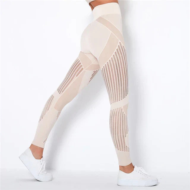 Side view of beige high-waisted leggings with vertical sheer stripe panels, worn with white trainers 1