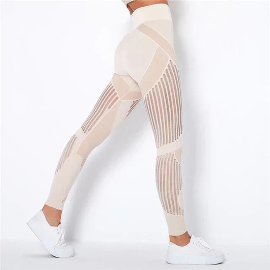 Side view of beige high-waisted leggings with vertical sheer stripe panels, worn with white trainers 1