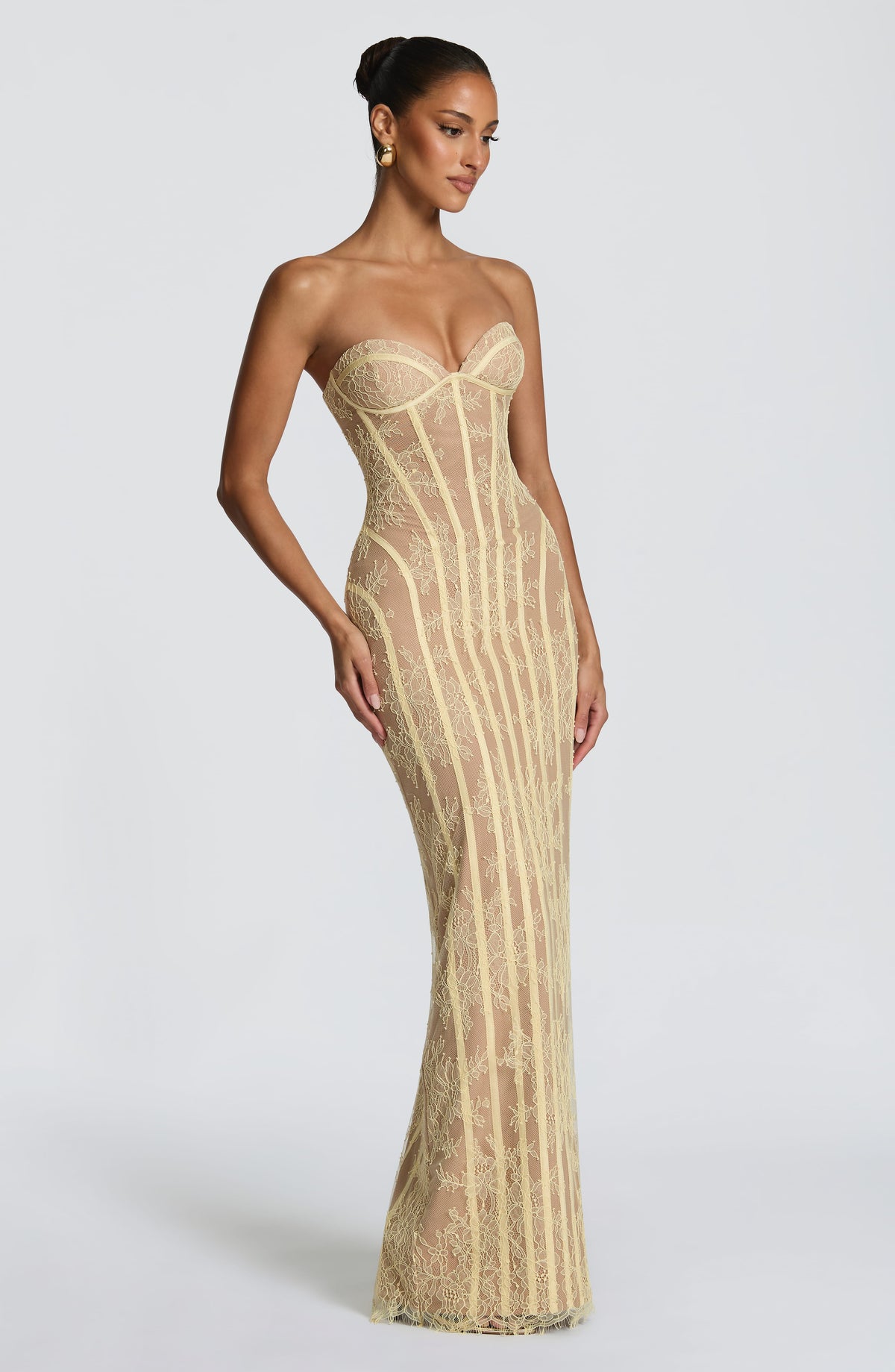 Angled view of the pale yellow lace dress, showing the strapless sweetheart neckline, seamed hips and floral lace over a nude lining. 19