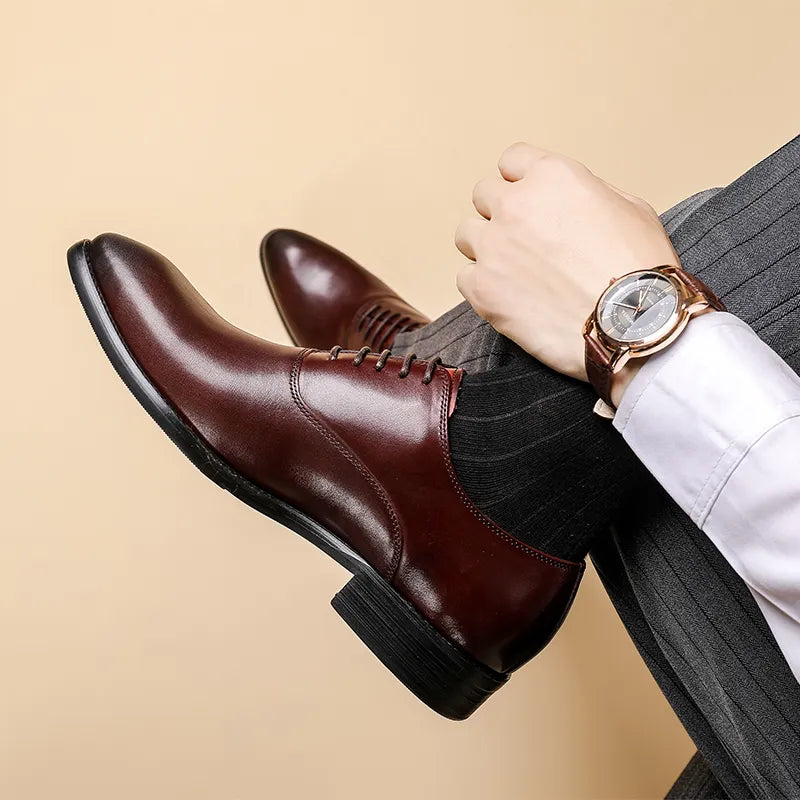 Glossy burgundy leather Oxford seen from the side on a seated model with legs crossed, wearing a wristwatch 2