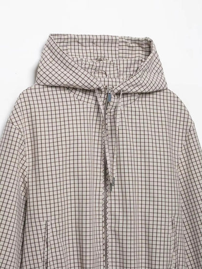 Flat lay of the jacket's upper half, showing the hood, zip, drawstring toggles and slanted side pockets. 7
