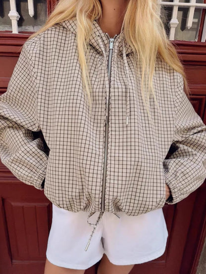 Close-up of the jacket's front on the model, showing the metal zip, hood drawstrings and gathered drawstring hem. 3