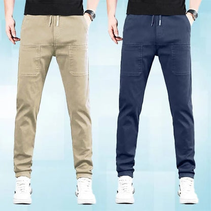 Two men side by side wearing drawstring trousers with large front pockets, one in beige and one in navy 21