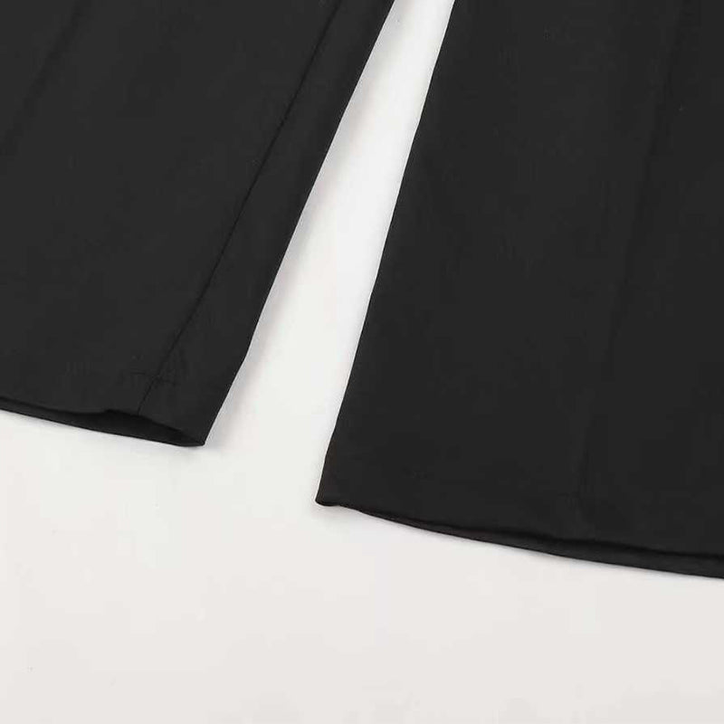 Flat-lay close-up of the black trouser hems laid side by side, showing the clean stitched edges and the front crease. 15