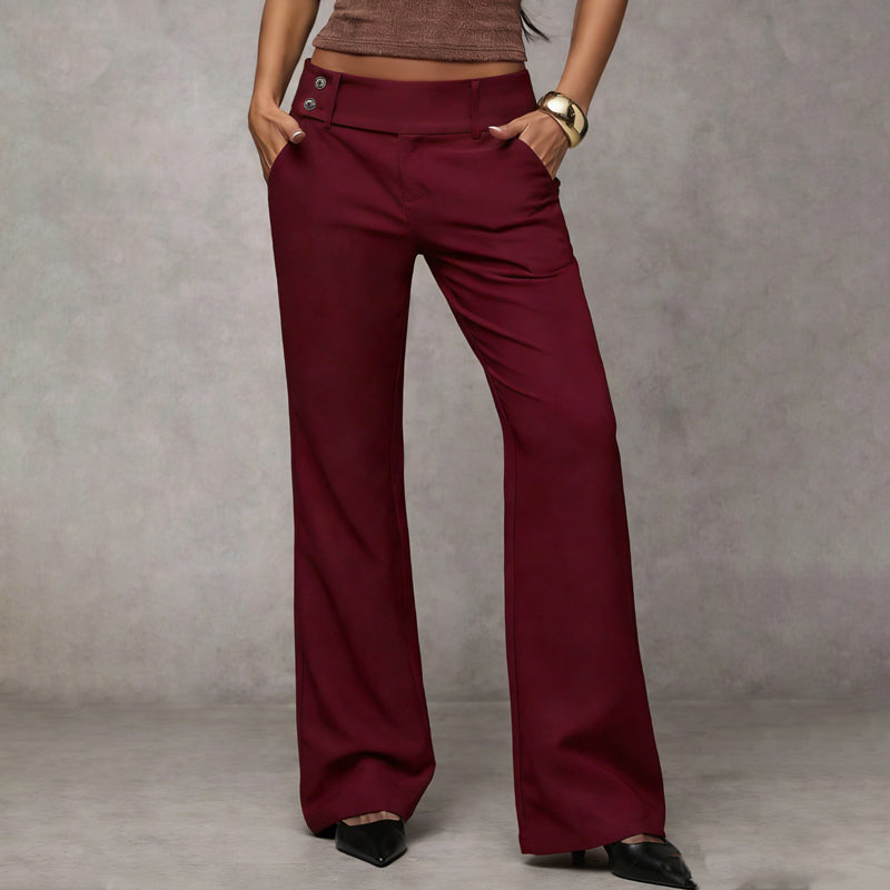 Front view of the trousers in burgundy red, worn with a brown top and a chunky gold bangle. 6