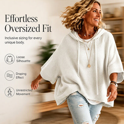 Laughing woman in motion wearing a white oversized hooded knit jumper with ribbed trims, layered necklaces and ripped jeans. 4